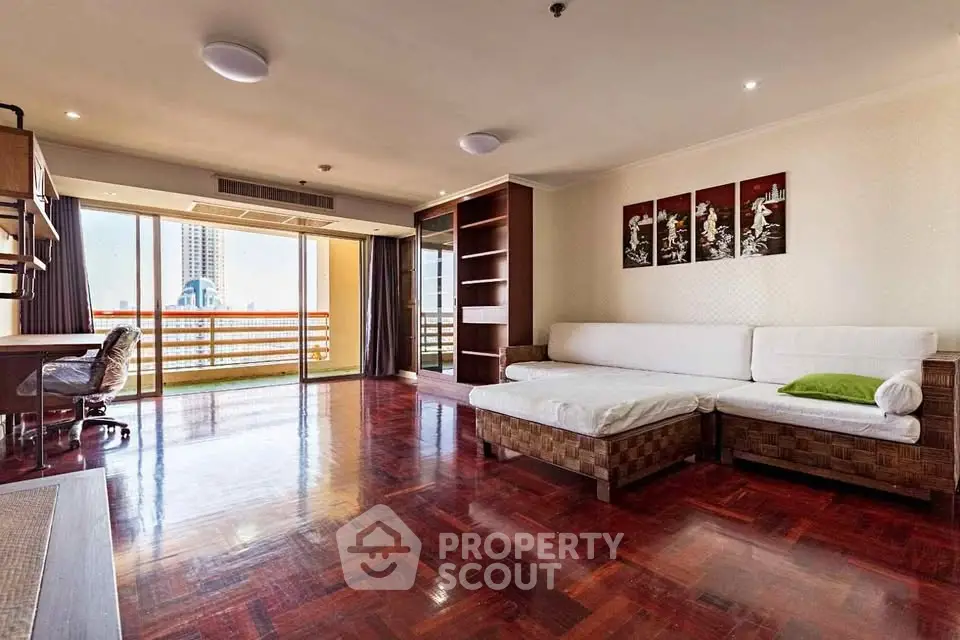 Spacious living room with hardwood floors and balcony view in modern apartment