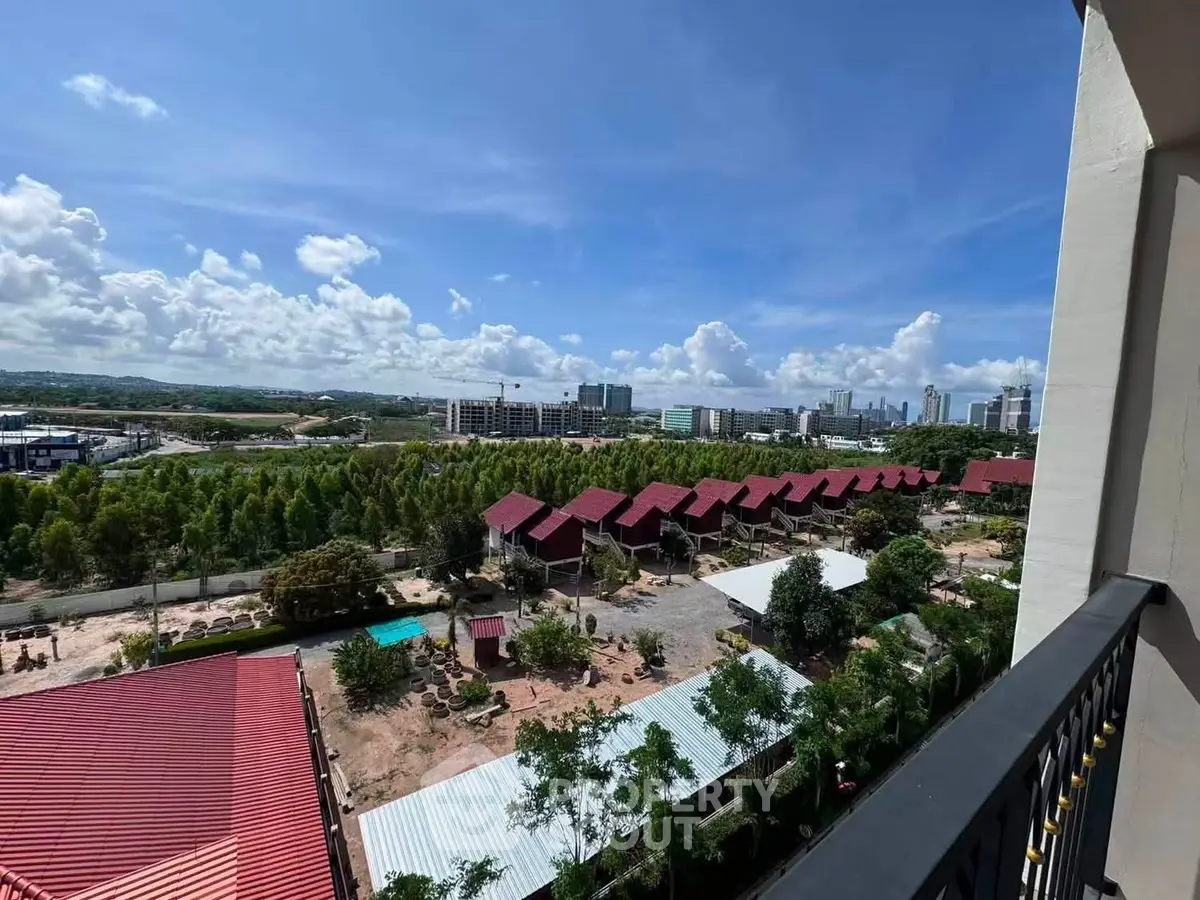 Stunning panoramic view from a balcony overlooking a serene residential area with red-roofed houses.