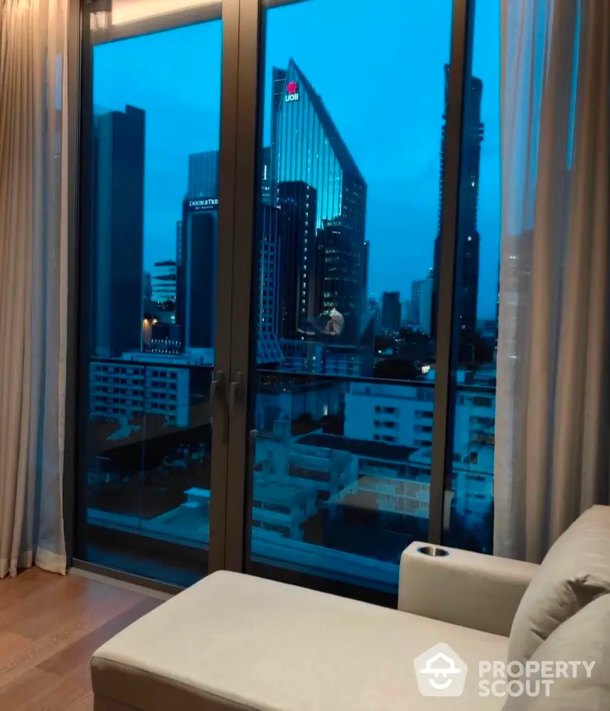 Luxurious city view from modern apartment living room with floor-to-ceiling windows.