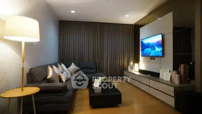 Modern living room with sleek furniture and ambient lighting, featuring a wall-mounted TV and stylish decor.