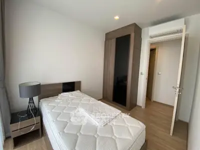 Modern minimalist bedroom with wooden flooring and sleek furniture design.
