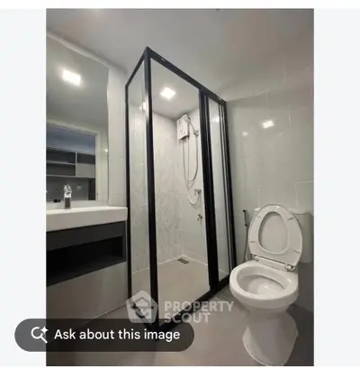 Modern bathroom with glass shower enclosure and sleek fixtures.