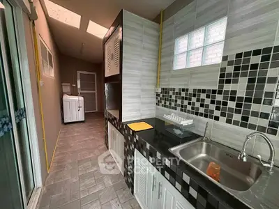 Modern kitchen with sleek black countertops and stylish tile backsplash