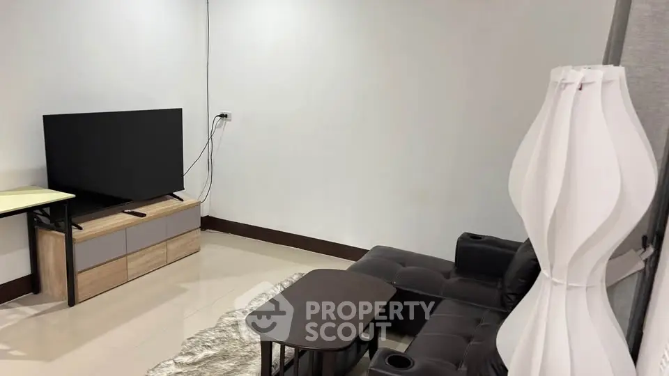 Modern living room with sleek furniture and large TV, perfect for relaxation and entertainment.