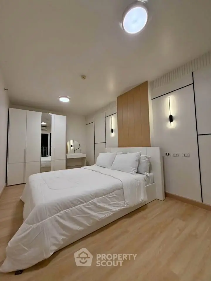 Modern bedroom with sleek design, featuring a cozy bed, stylish wardrobe, and elegant lighting.