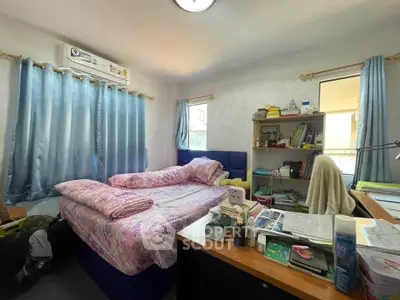 Cozy bedroom with ample natural light, featuring a comfortable bed and organized study area, perfect for relaxation and work.