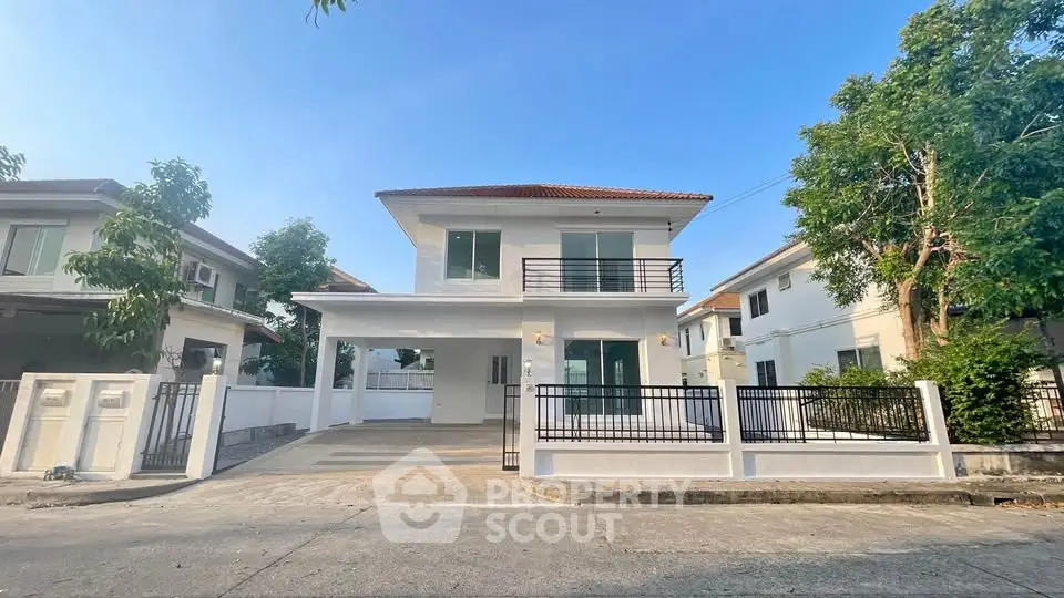 Charming two-story white house with spacious driveway and modern design in a serene neighborhood.