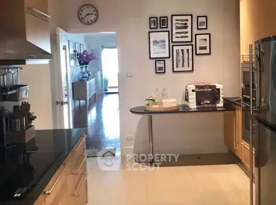 Modern kitchen with sleek appliances and stylish decor, featuring open layout and elegant wall art.