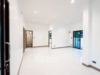 Spacious modern living room with large windows and sleek white flooring