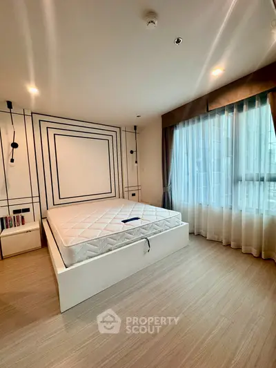 Spacious modern bedroom with large window and stylish decor