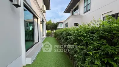 Modern house exterior with lush green garden and large windows