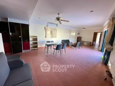 Spacious living room with modern furniture and ceiling fans, ideal for family gatherings.
