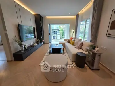 Modern living room with stylish decor and large windows opening to a balcony.