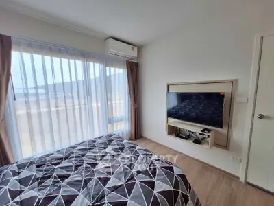 Modern bedroom with large window and wall-mounted TV