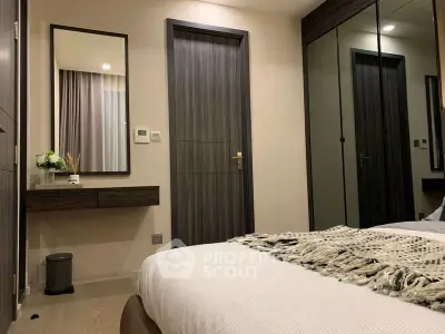 Modern bedroom with stylish decor and mirrored wardrobe in a cozy apartment.