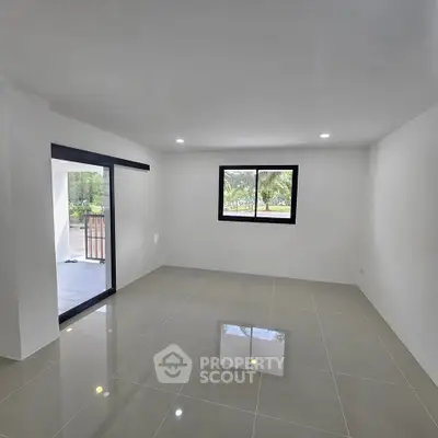 Spacious empty living room with large window and sliding door to balcony