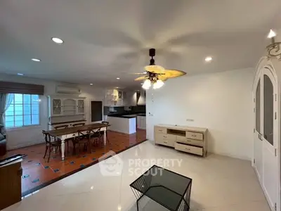 Spacious open-plan living and dining area with modern kitchen and stylish lighting.