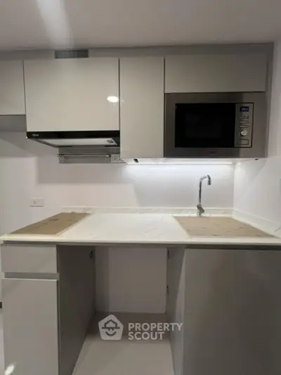 Modern kitchen with sleek cabinetry and built-in microwave oven