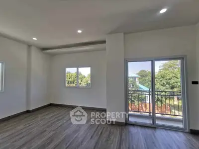 Spacious and bright interior with large windows and balcony access, perfect for modern living.