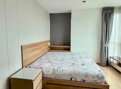 Spacious bedroom with large window and modern wooden furniture in a bright apartment.