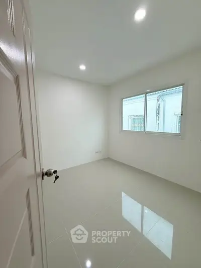 Bright empty room with glossy tiled floor and large window, perfect for customization.