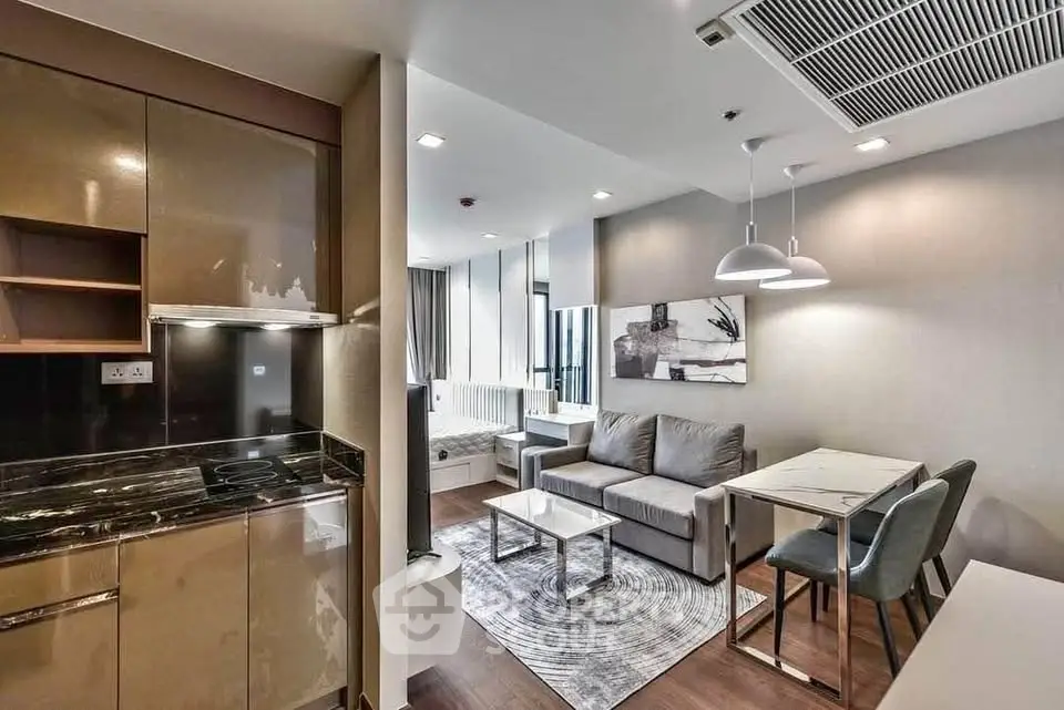Modern open-plan living room with sleek kitchen and stylish decor in a contemporary apartment.