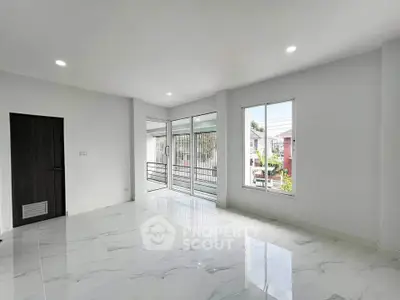 Spacious modern living room with large windows and balcony access, featuring sleek marble flooring.