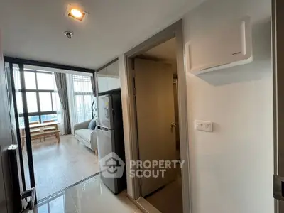 Modern apartment interior with open layout, featuring a cozy living room and kitchen area with natural light.