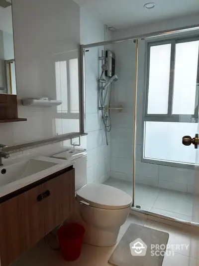 Modern bathroom with glass shower and sleek fixtures in a contemporary home.