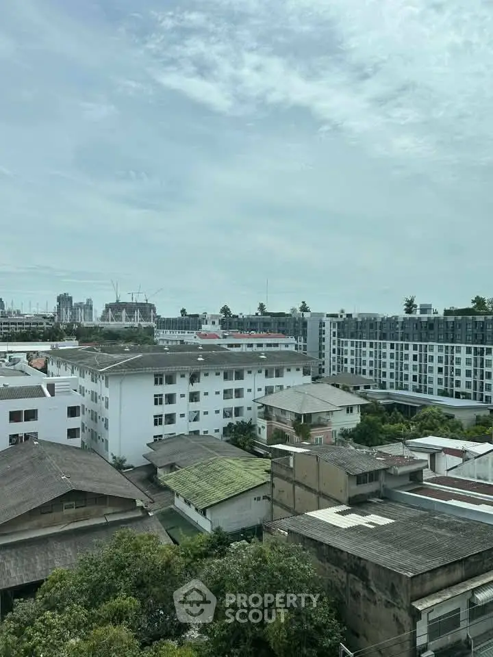 Scenic urban view showcasing residential buildings and lush greenery under a clear sky.