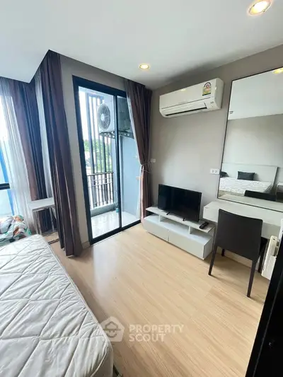 Modern bedroom with balcony access and air conditioning in a stylish apartment.