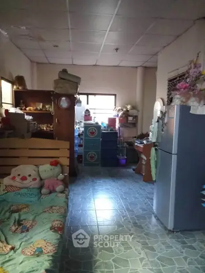 Cozy living space with tiled flooring and eclectic decor, featuring a fridge and ample storage.