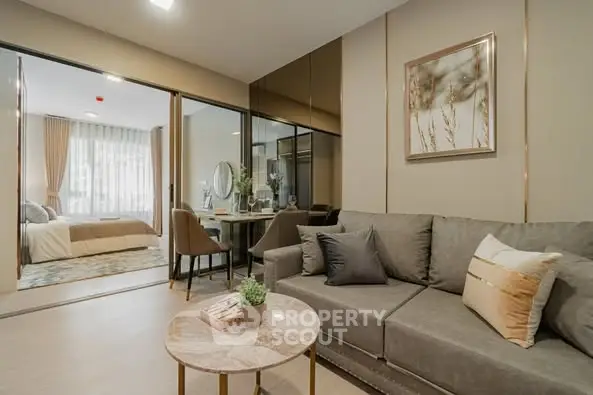 Modern living room with elegant decor and open view into bedroom