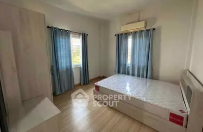 Spacious bedroom with natural light and modern furnishings