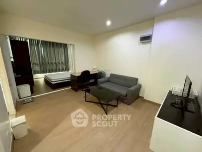 Modern studio apartment with cozy living area and bedroom, featuring sleek furniture and ambient lighting.