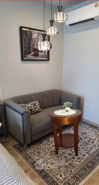 Cozy living room with stylish sofa, elegant lighting, and wall art, perfect for relaxation.