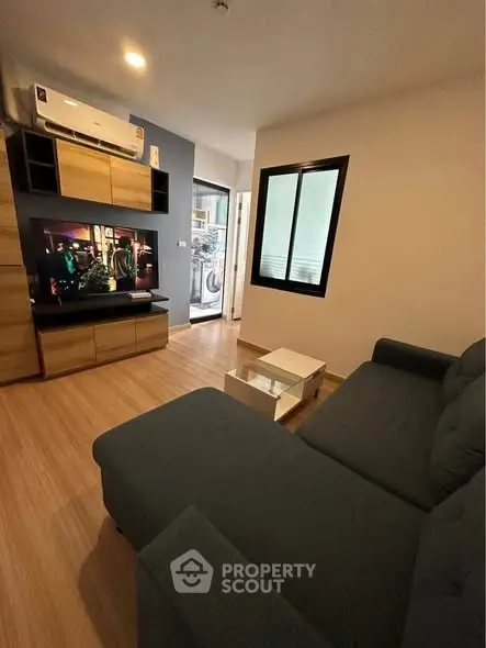 Modern living room with stylish furniture and entertainment setup in a cozy apartment.