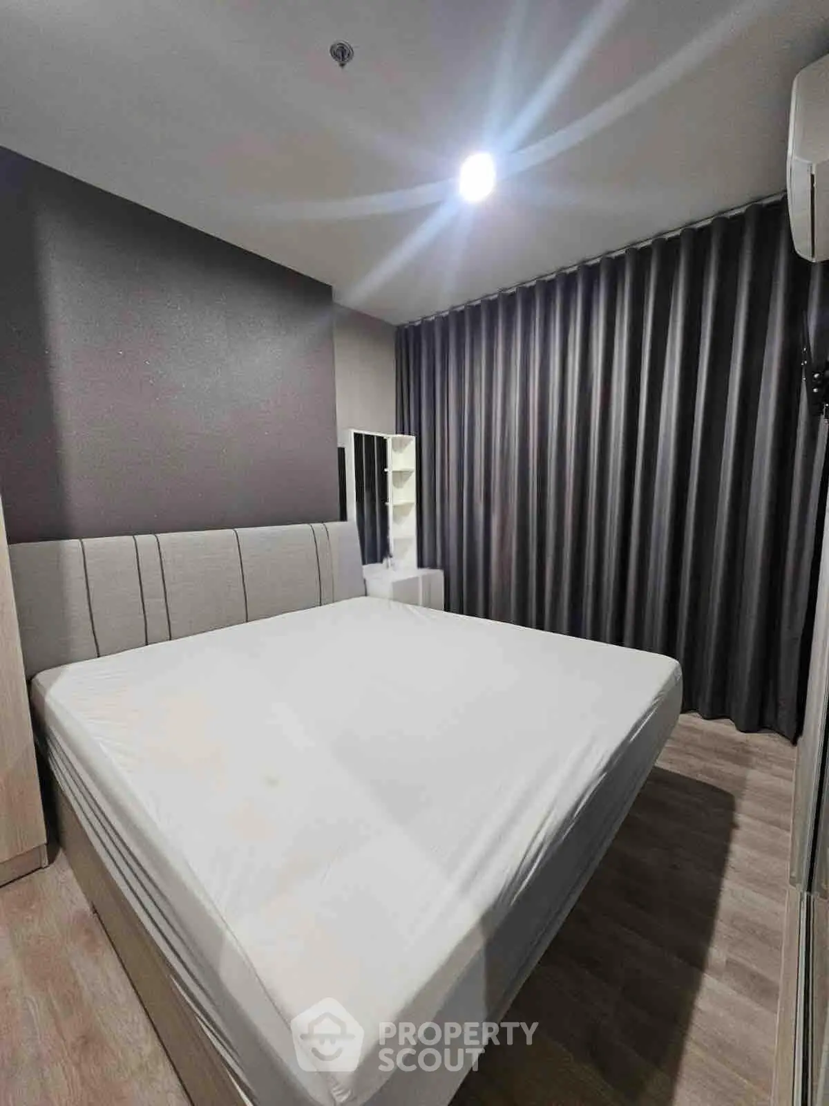Modern bedroom with stylish decor and ample natural light, featuring a comfortable bed and sleek furnishings.