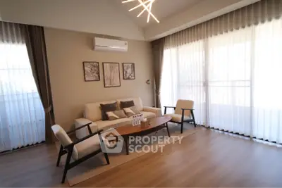 Modern living room with stylish furniture and large windows