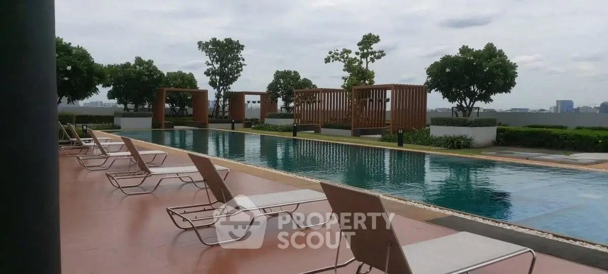 Luxurious rooftop pool with stylish lounge chairs and city skyline view, perfect for relaxation and leisure.