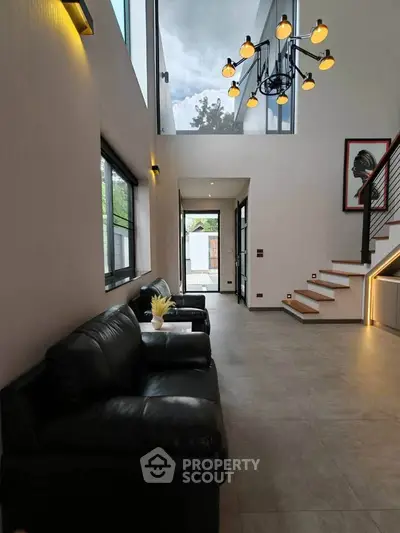 Modern living room with high ceiling and stylish chandelier