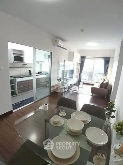 Modern open-plan living room with dining area and kitchen in a stylish apartment.