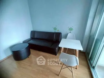 Modern minimalist living room with sleek black sofa and stylish dining set.