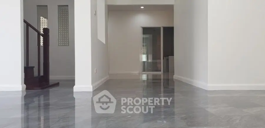 Spacious modern interior with glossy marble flooring and elegant staircase.
