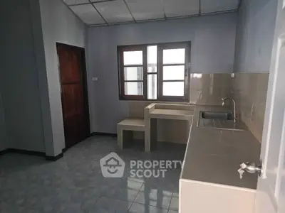 Spacious kitchen with modern sink and ample counter space in a well-lit room.