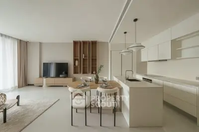 Modern open-plan living room and kitchen with sleek design and neutral tones.