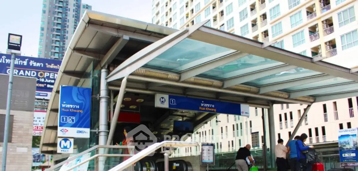 Modern urban entrance to Hua Khwang MRT station with nearby high-rise buildings.