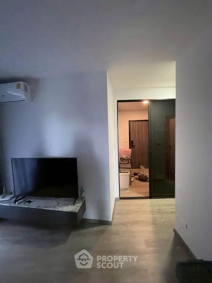 Modern living room with sleek TV setup and air conditioning, featuring a stylish open layout.