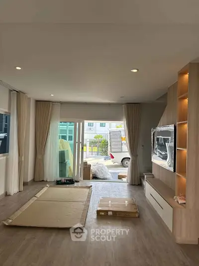 Spacious living room with modern built-in entertainment unit and large windows.