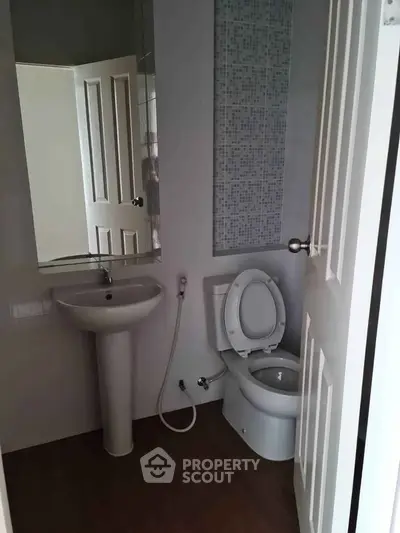 Compact bathroom with modern fixtures and tiled accent wall.